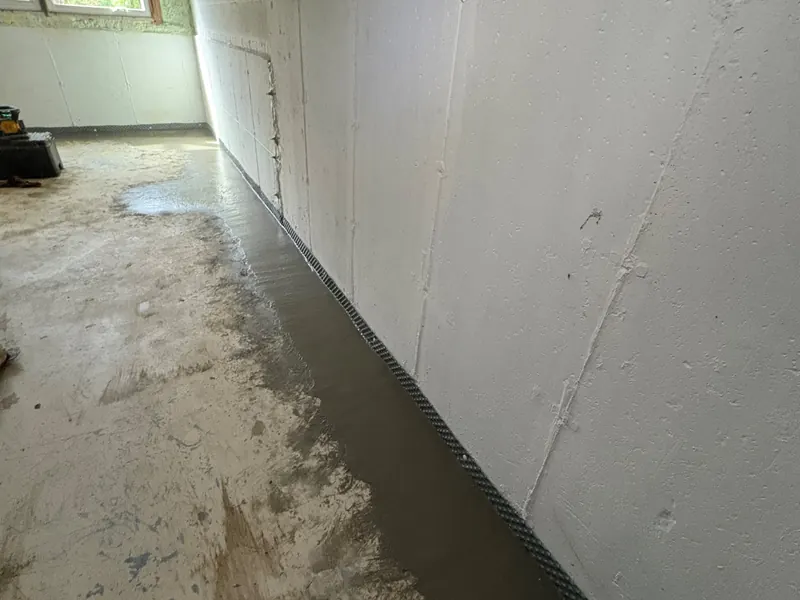 After: a finished basement room where water was coming in at the base of the wall