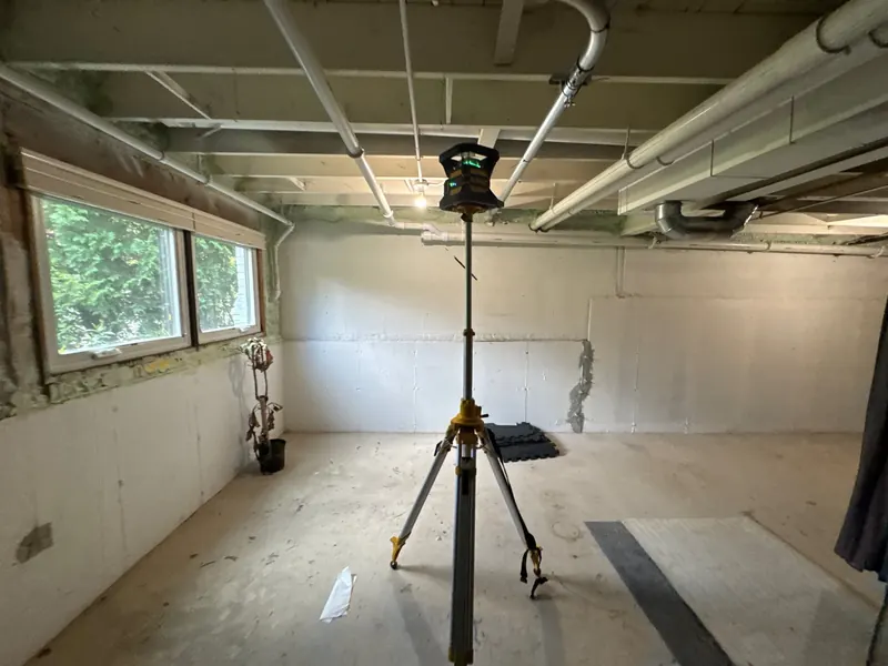 Before: a finished basement room where water was coming in at the base of the wall