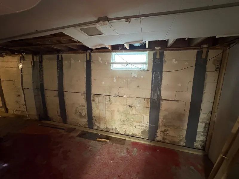 After: a cracked basement block wall, then the same basement with steel braces installed against the wall