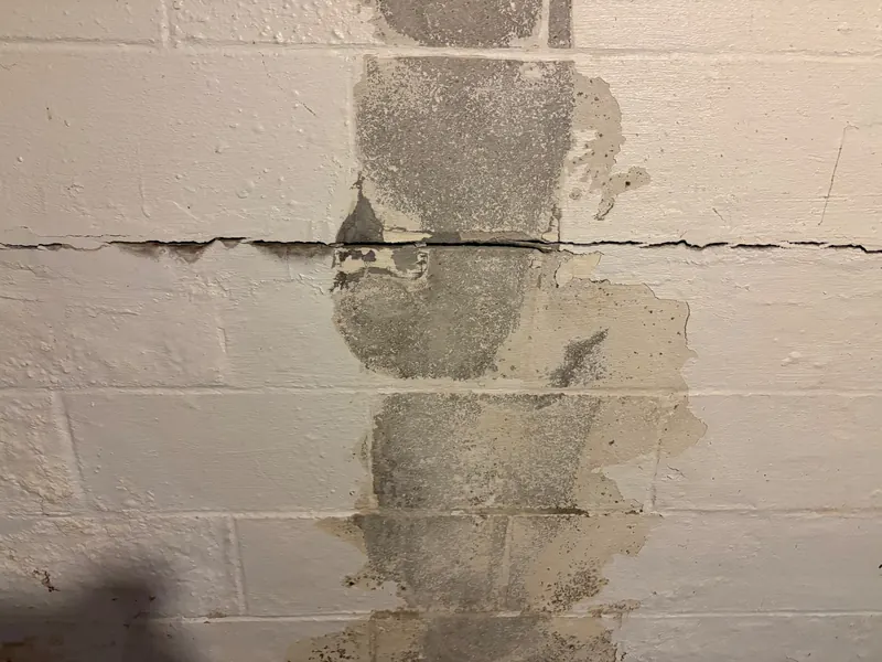 After: a crack running along a basement block wall, then the same wall sealed and patched