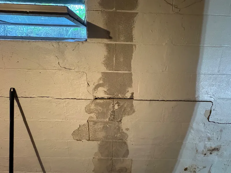 Before: a crack running along a basement block wall, then the same wall sealed and patched